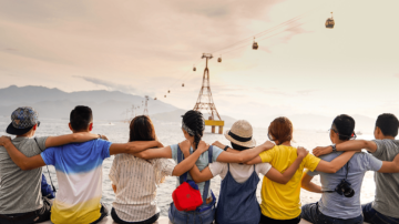 a group of people with their arms over each other shoulders looking out at a trolly