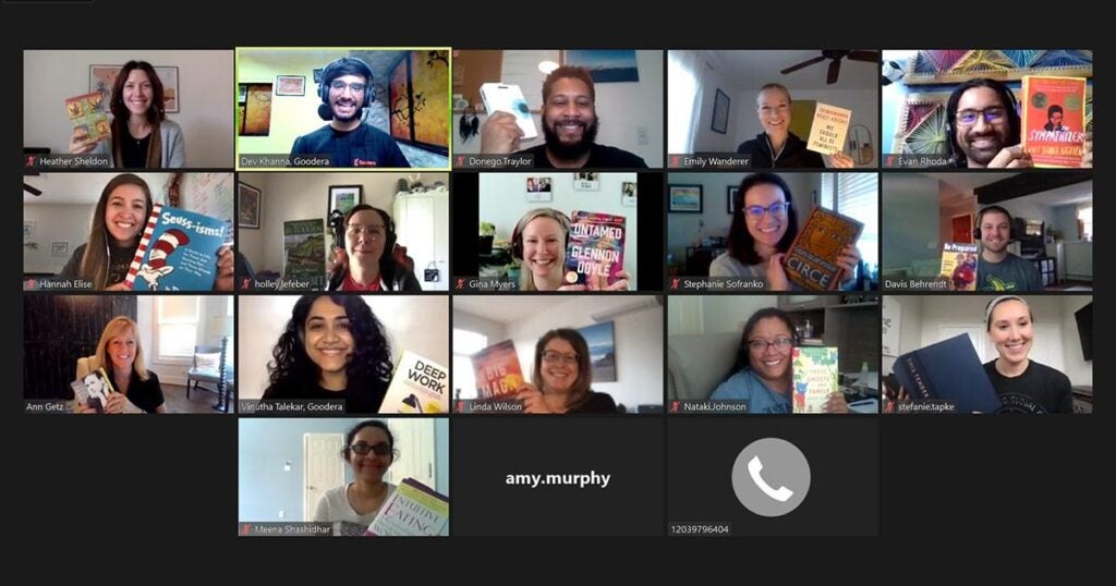 virtual meeting where everyone is holding up a book